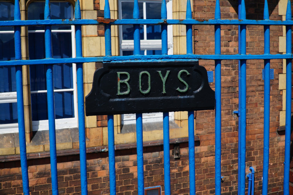 The sign says 'Boys' on railings at Benson Community School: image by Tim Ellis, CC By-NC 2.0