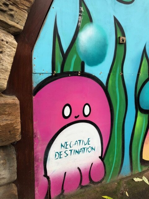 Graffiti from lockdown 2020, a mournful face is inscribed 'negative destination'