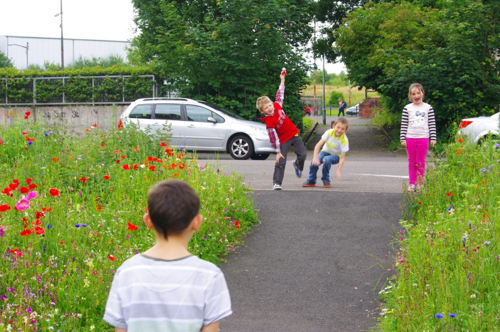 Kids play on the 'Brothers Path' a vacant site transformed with wild flowers: picture Depot Arts
