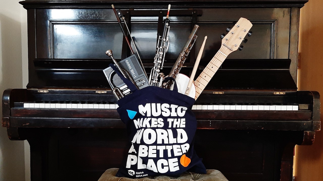 A piano with the PPL tote bag, Music Makes the World a Better Place