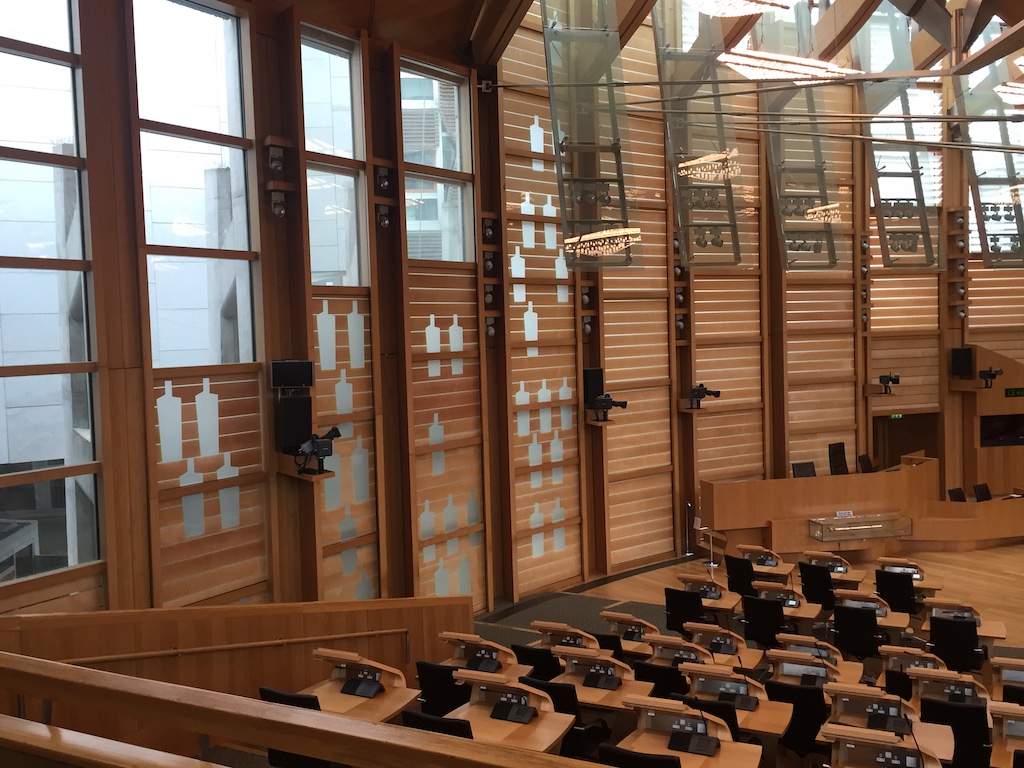 Scottish Parliament debating chamber, empty on Friday – 'bottles' represent the people represented by MSPs