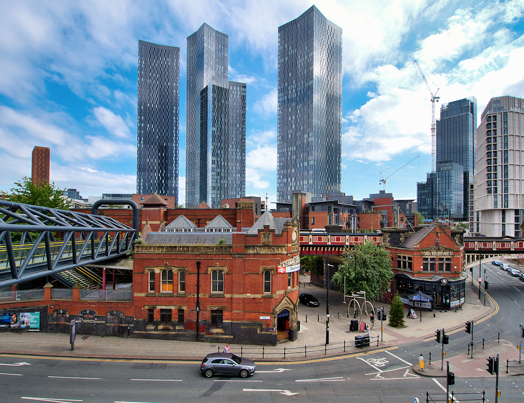 Towering glass and steel tower blocks over the red brick of Manchester's old Knott Mill. Photo by by David Dixon CC BY-SA 2.0