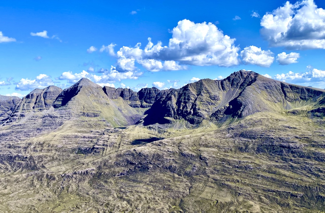 A view of the grey mounting Laithach topped by blue sky and white clouds